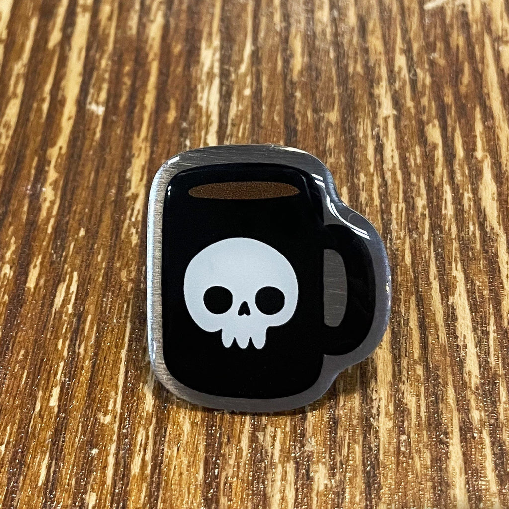 Black kettlebell-shaped object with a white skull design on a wooden surface, branded 'Rapscallion'.